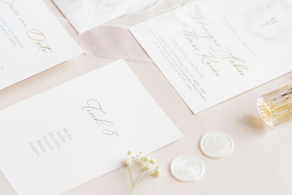 Minimalist white wedding invitation suite with elegant calligraphy.