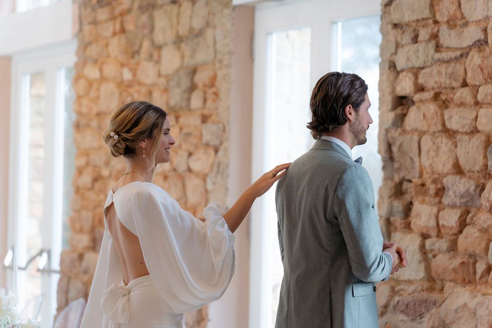 Emotional wedding first look sequence in a venue with exposed stone walls.