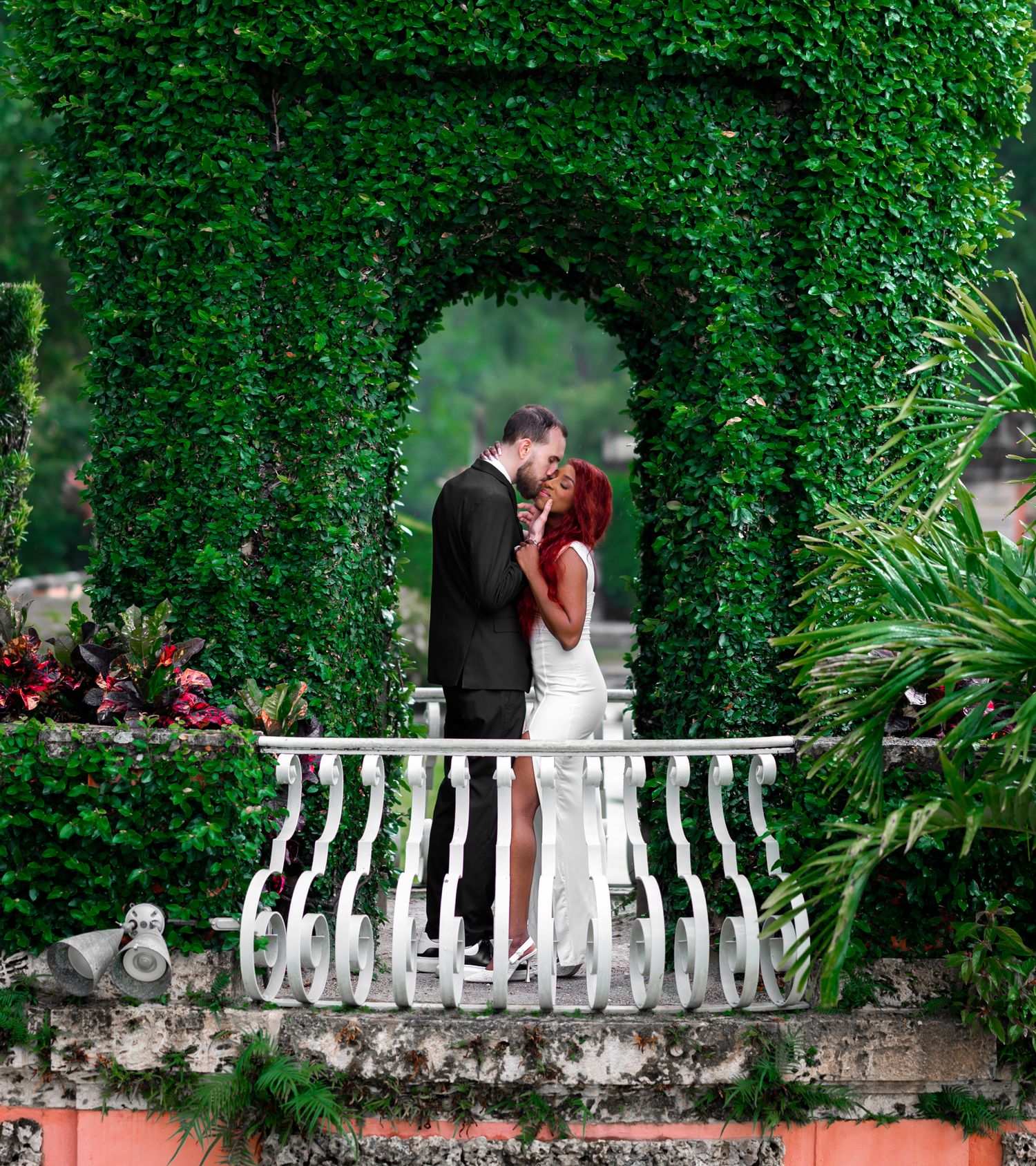 The groom steals a kiss from his bride at the Vizcaya Museum in Miami, Florida.