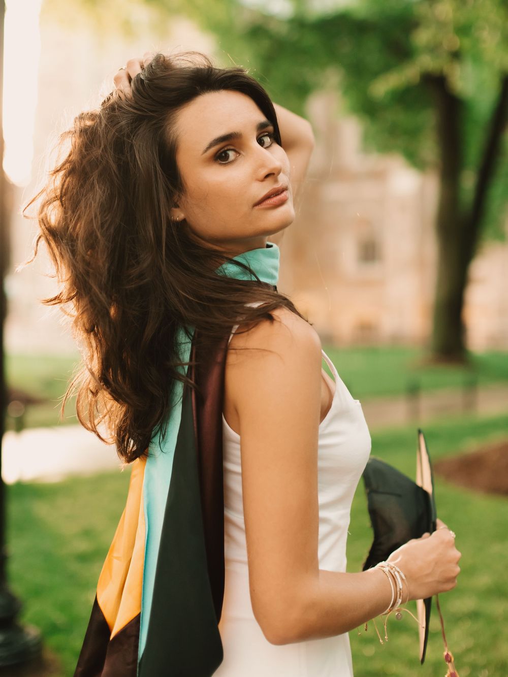 Boston college graduate on campus in a cinematic golden hour setting wearing cap & sash