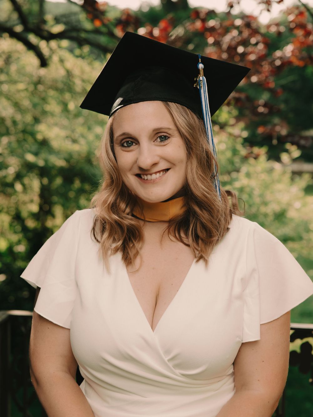 Womens graduation cap & gown senior photos on college campus