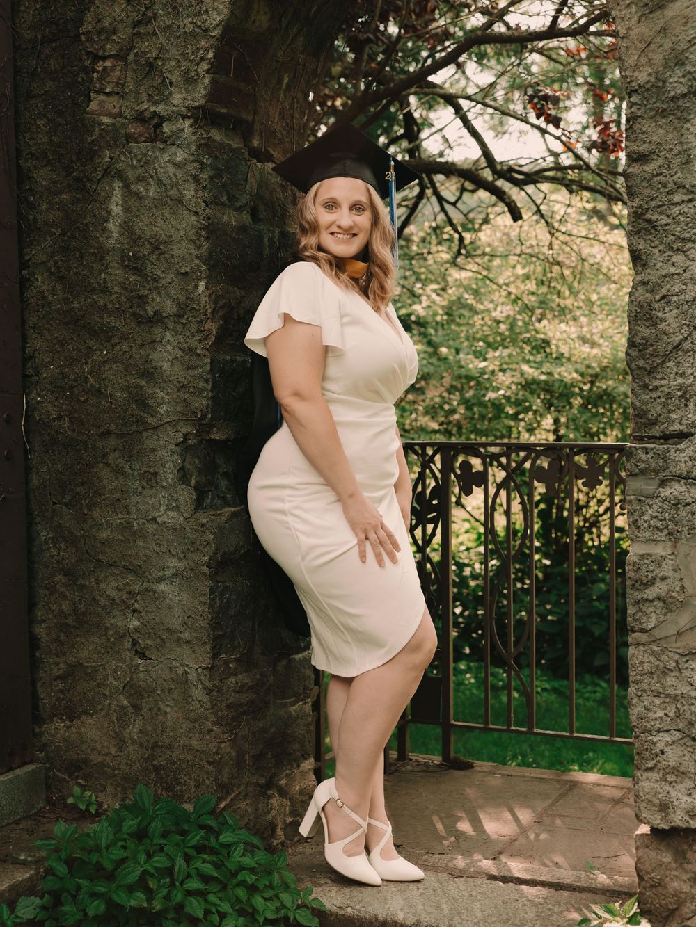 Womens graduation cap & gown senior photos on college campus