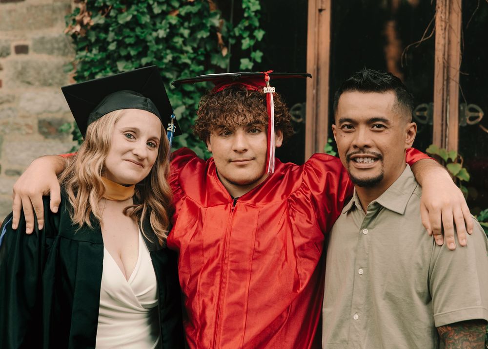 Mom, father, & son graduation photos with cap & gown on college campus