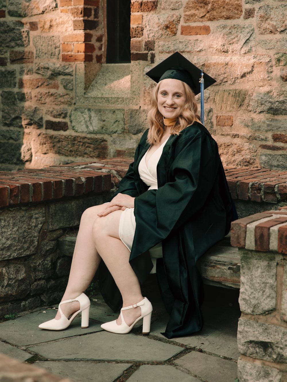 Womens graduation cap & gown senior photos on college campus