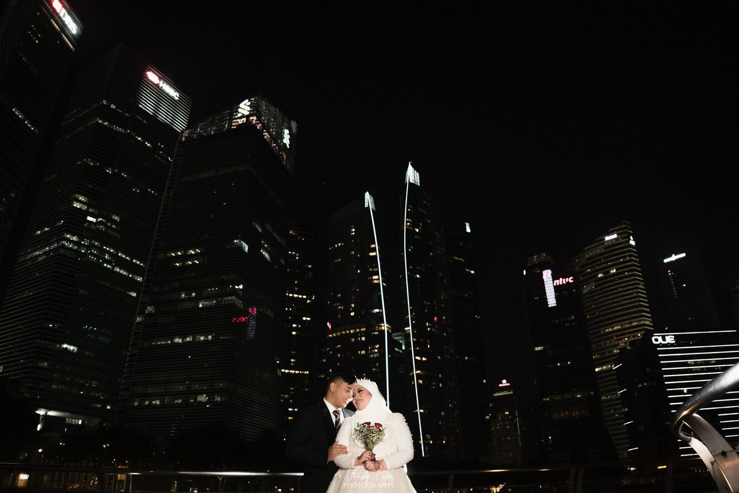 Intimate moment captured under white arched colonnade with classic architecture.