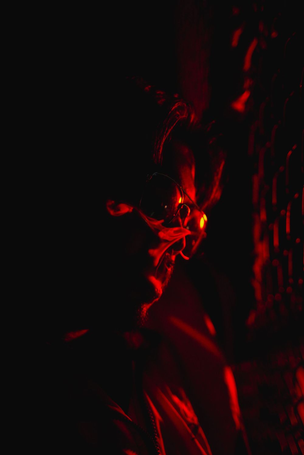 Abstract dark red light patterns swirling dramatically against a black background, creating an eerie and mysterious atmosphere.
