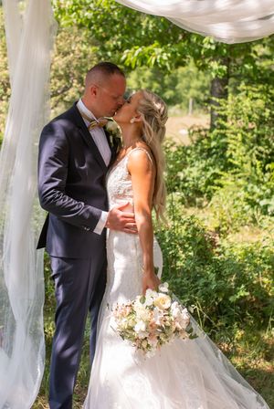 Brudpar kysser varann i grönskan