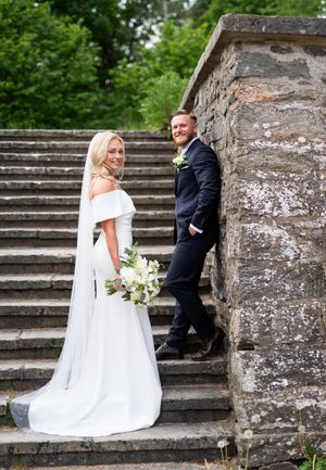 Brudpar står i en fin stentrappa vid Gunnebo slott