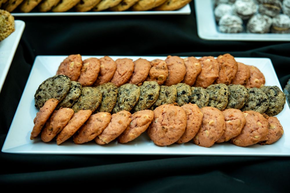 Assorted cookies including chocolate chip and oatmeal varieties arranged on a white rectangular platter.