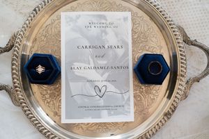 Wedding stationery flat lay with navy velvet ring boxes and silver tray for Carrigan Sears and Elay Galdamez-Santos.