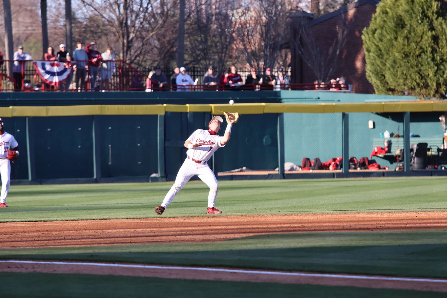 South Carolina infielder raises his glove to catch a fly ball.