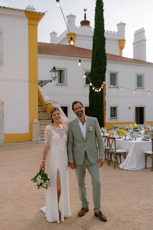 Bride and groom standing next to reception tables at their wedding in Torre de Palma in Alentejo