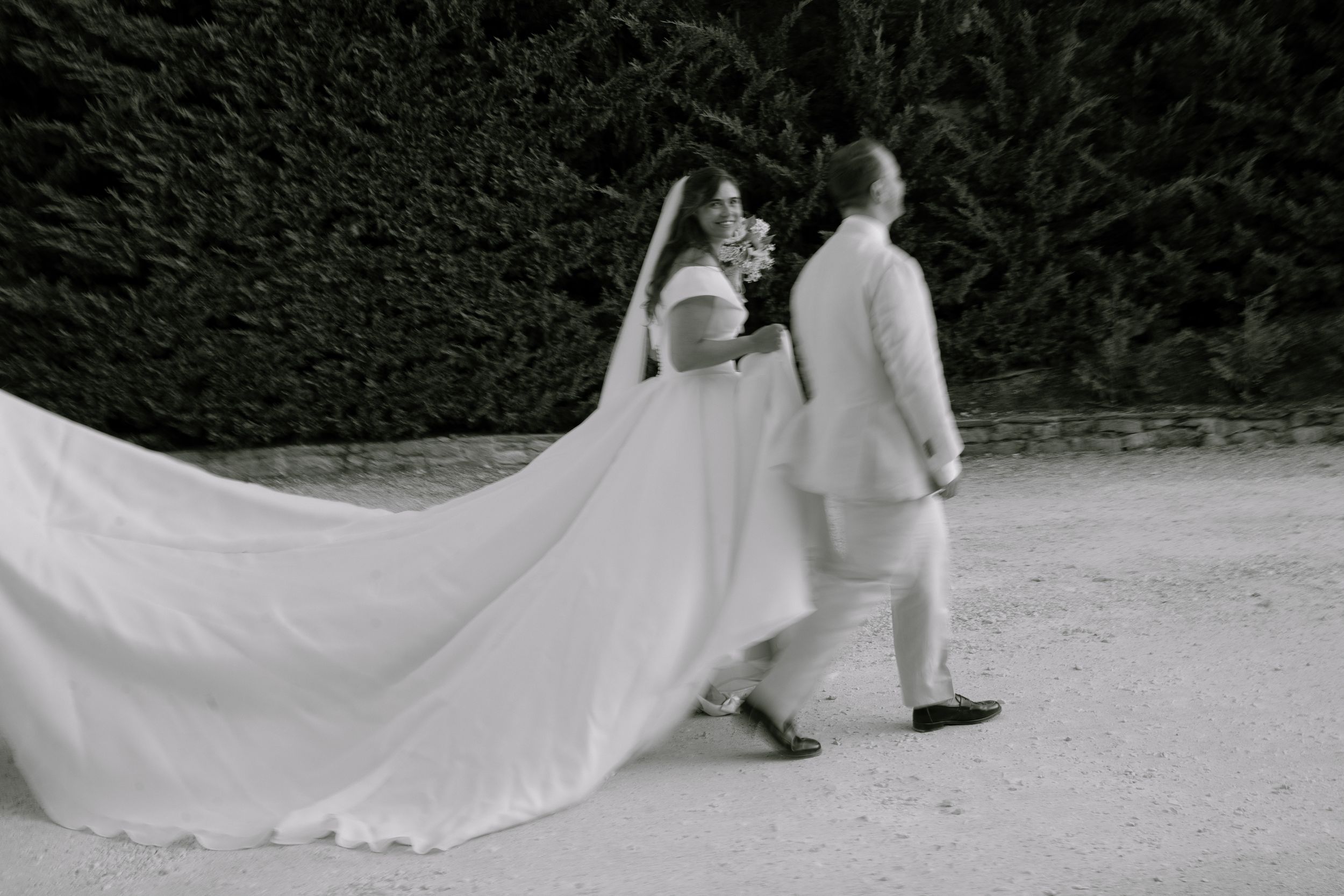 Black and white blurred movement modern candid moment of bride walking with groom