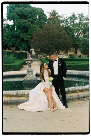 Analog portrait of bride and groom at fountain in a garden