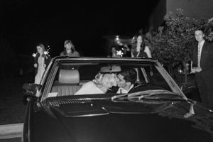 Black and white photo of a vintage car at night with wedding decor.