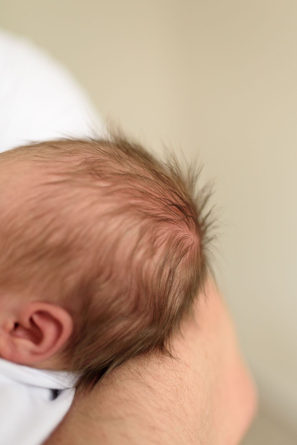 detail na dlouhé rozcuchané vlásky novorozeného miminka při newborn focení v Olomouci