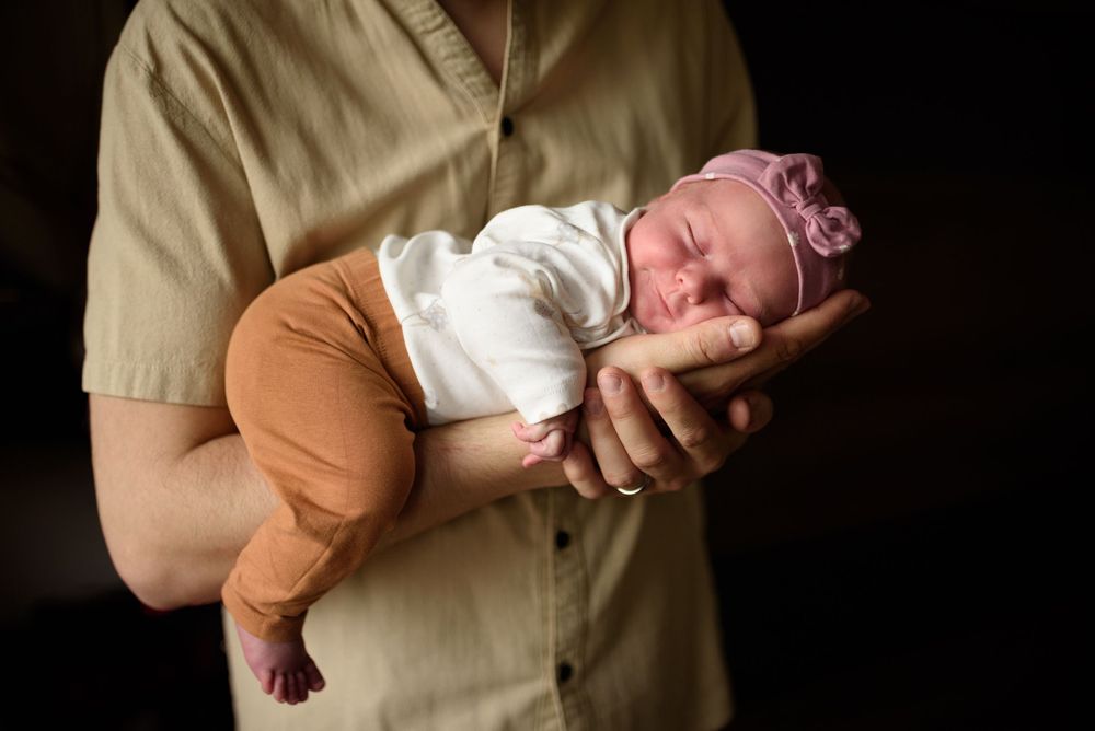 roztomilá newborn holčika při focení doma ve Vyškově leží v dlani tatínka