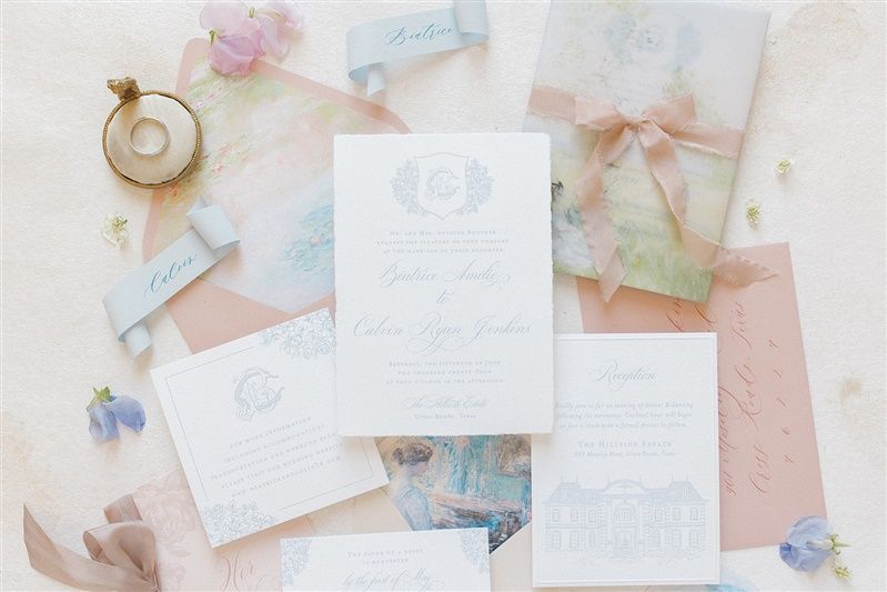 Elegant wedding invitation suite with delicate florals, pastel papers, and vintage pocket watch on light background.