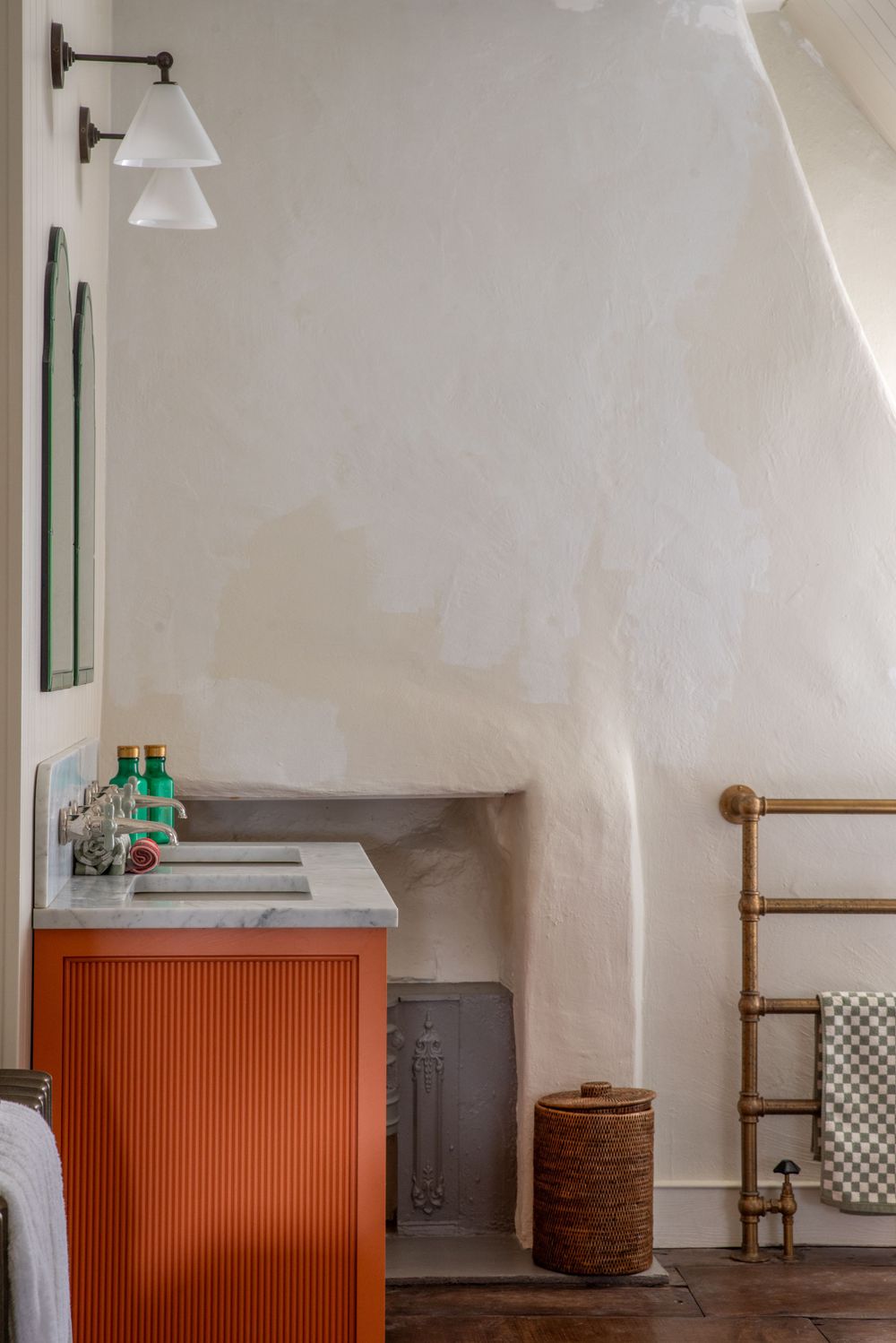 Modern interior with white walls and orange cabinets features pendant lights and minimalist decor.