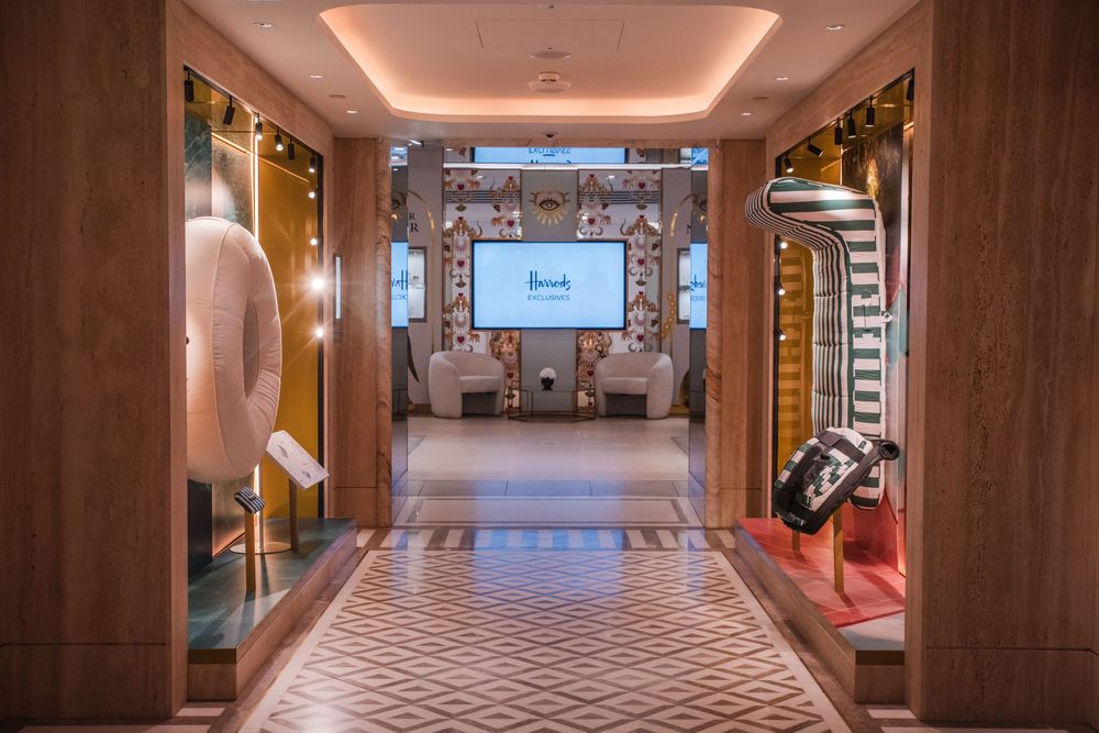 Long hallway with wood paneled walls and recessed lighting creating an elegant atmosphere. Harrods exhibition.