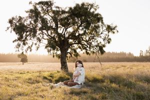 mum and daughter cuddling in open field in christchurch during motherhood session