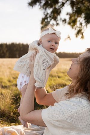 mum holding her baby up during motherhood session at Mcleans Island