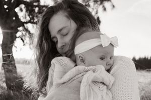 mum cradling her 3 month old baby during motherhood session at Mcleans Island