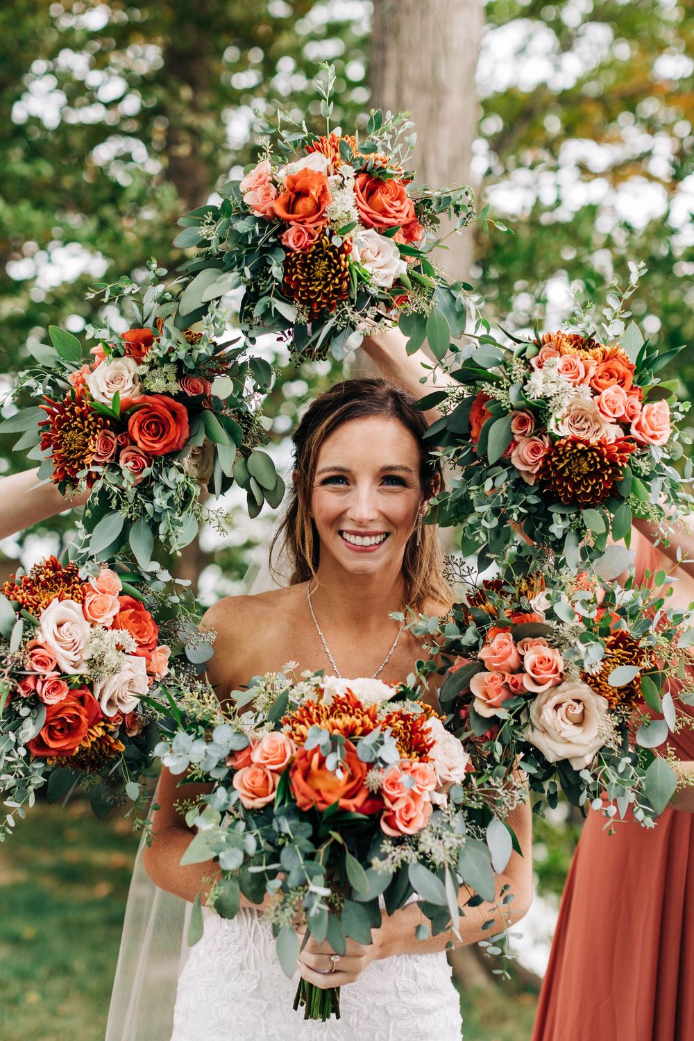 Beautiful floral arrangements in coral and peach tones with greenery create a stunning wedding bouquet display.