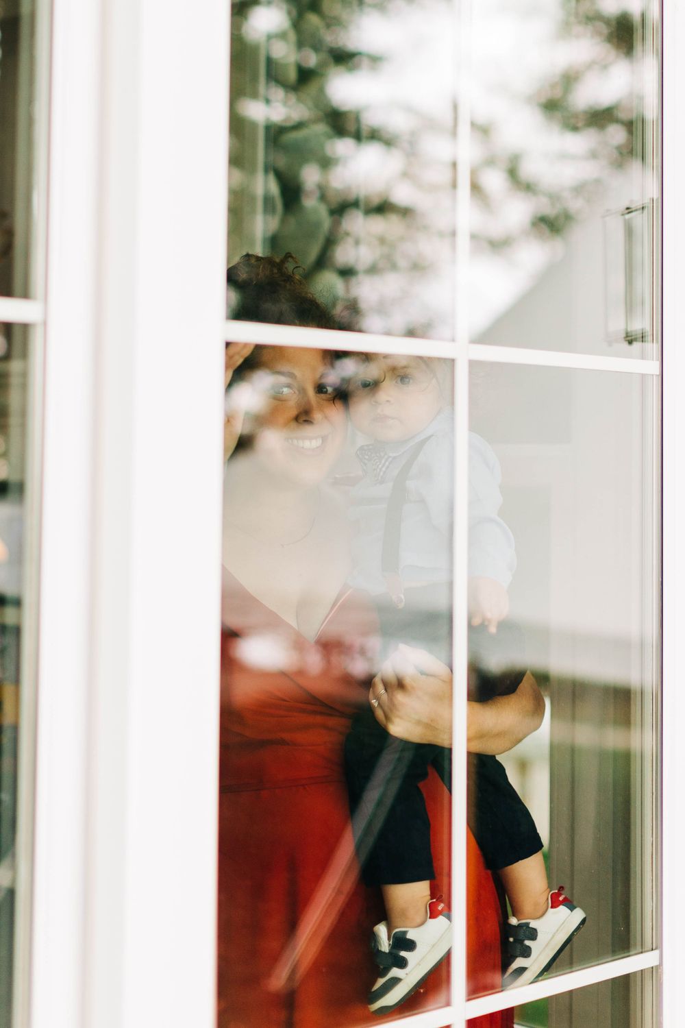 Artistic window reflection shot showing silhouetted figures through frosted glass panes.