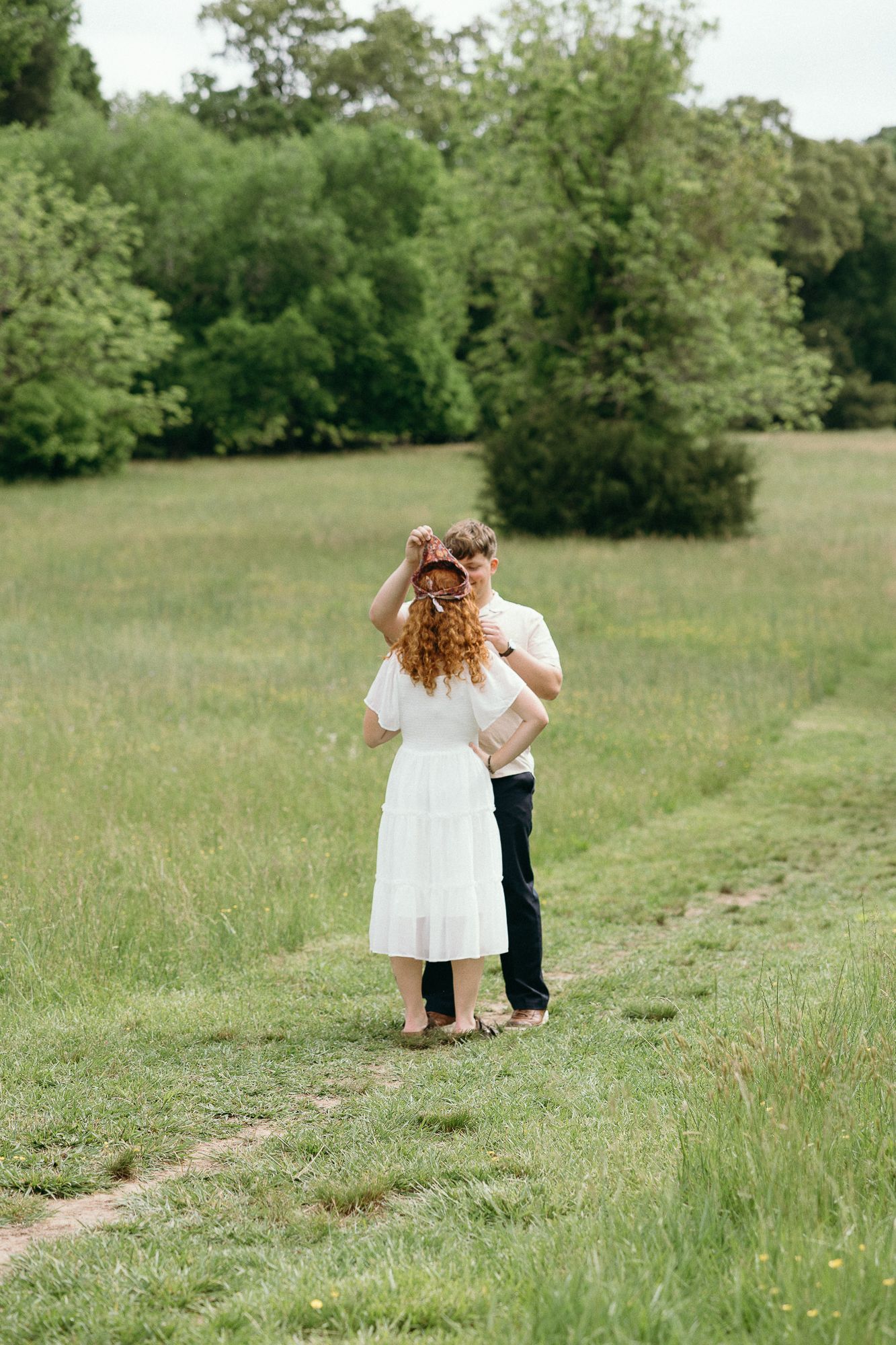 A romantic proposal moment captured in a green meadow. Twickenham House Wedding Photographer
