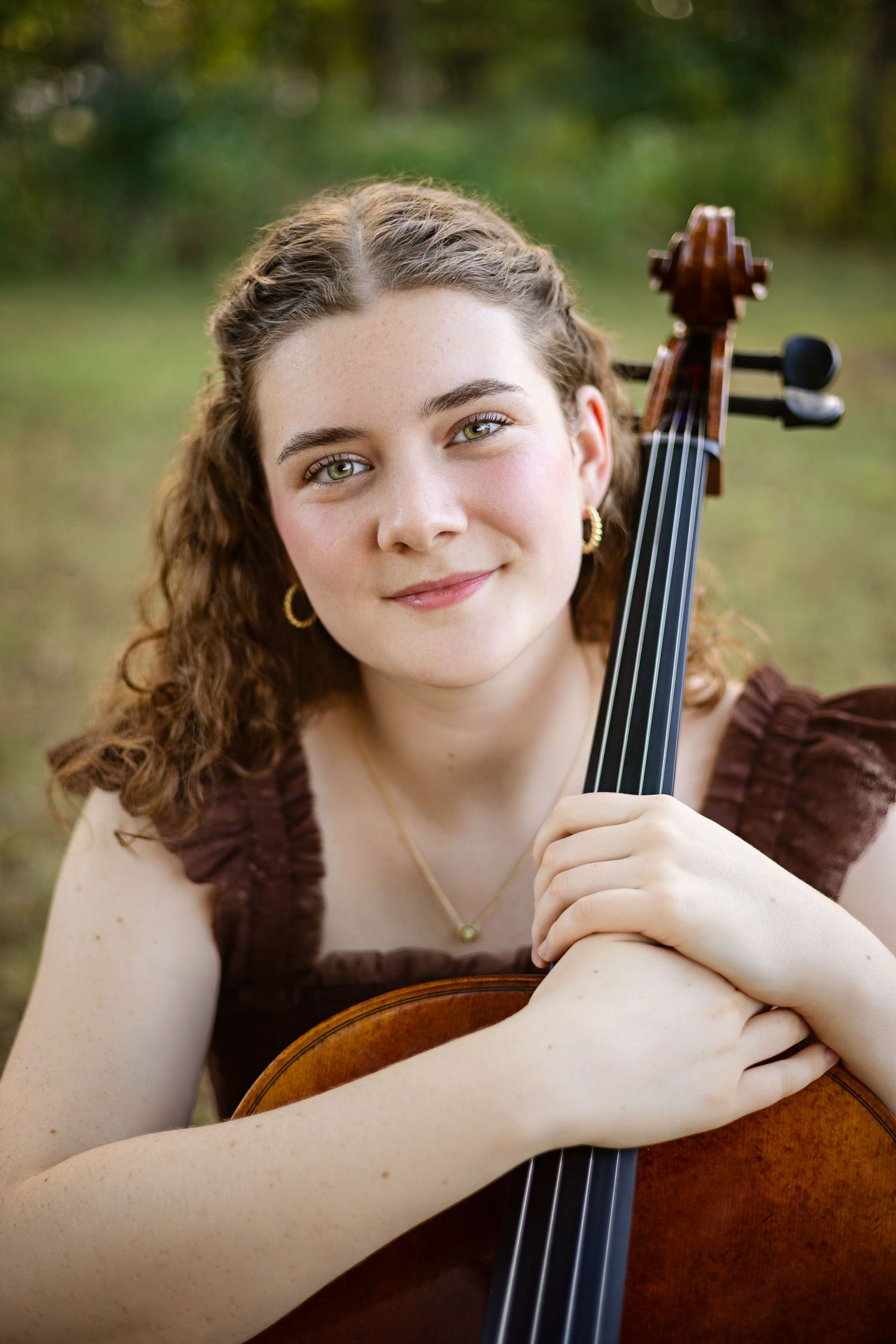 A musician poses outdoors with their cello in a series of expressive portraits against a natural background.