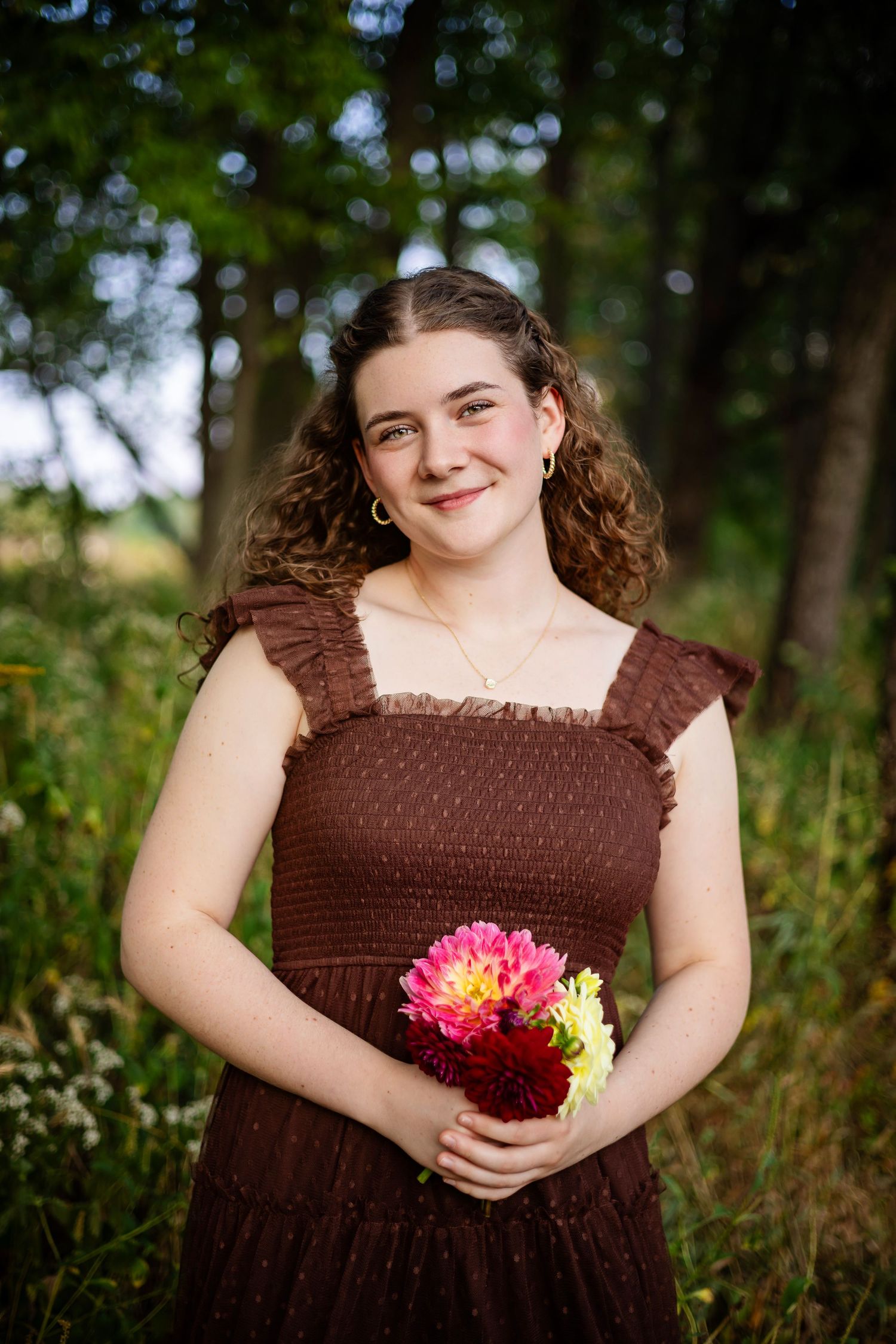 A series of outdoor portraits showing someone in a brown dress holding vibrant pink and yellow flowers in a natural setting.
