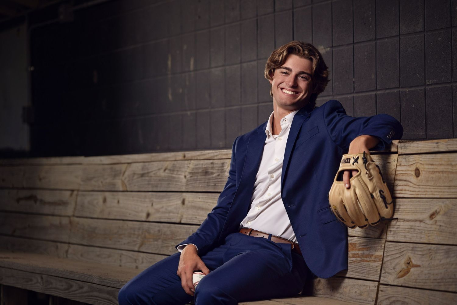 Professional headshot series showing person in navy suit jacket against rustic wooden wall background.