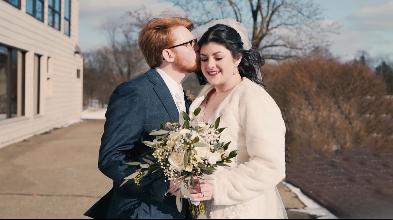 Winter wedding photos captured against brick building with soft natural light.
