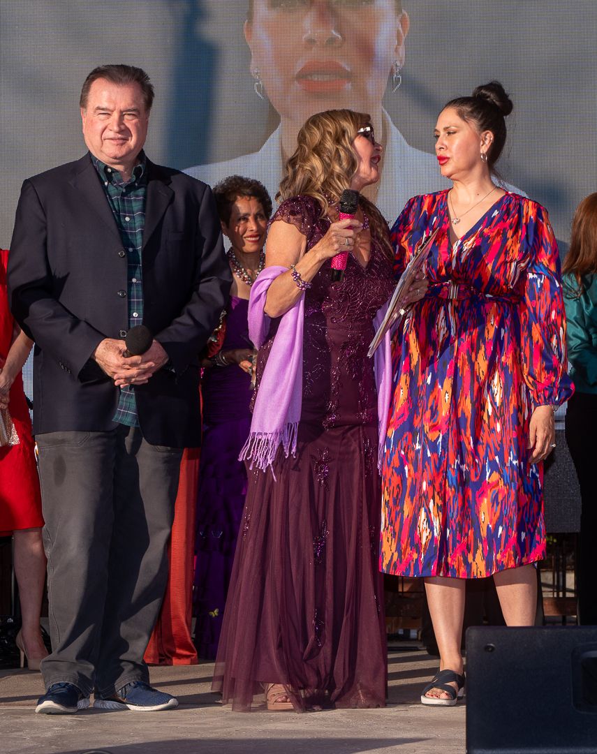 Stage performance group in colorful formal attire at an evening event.