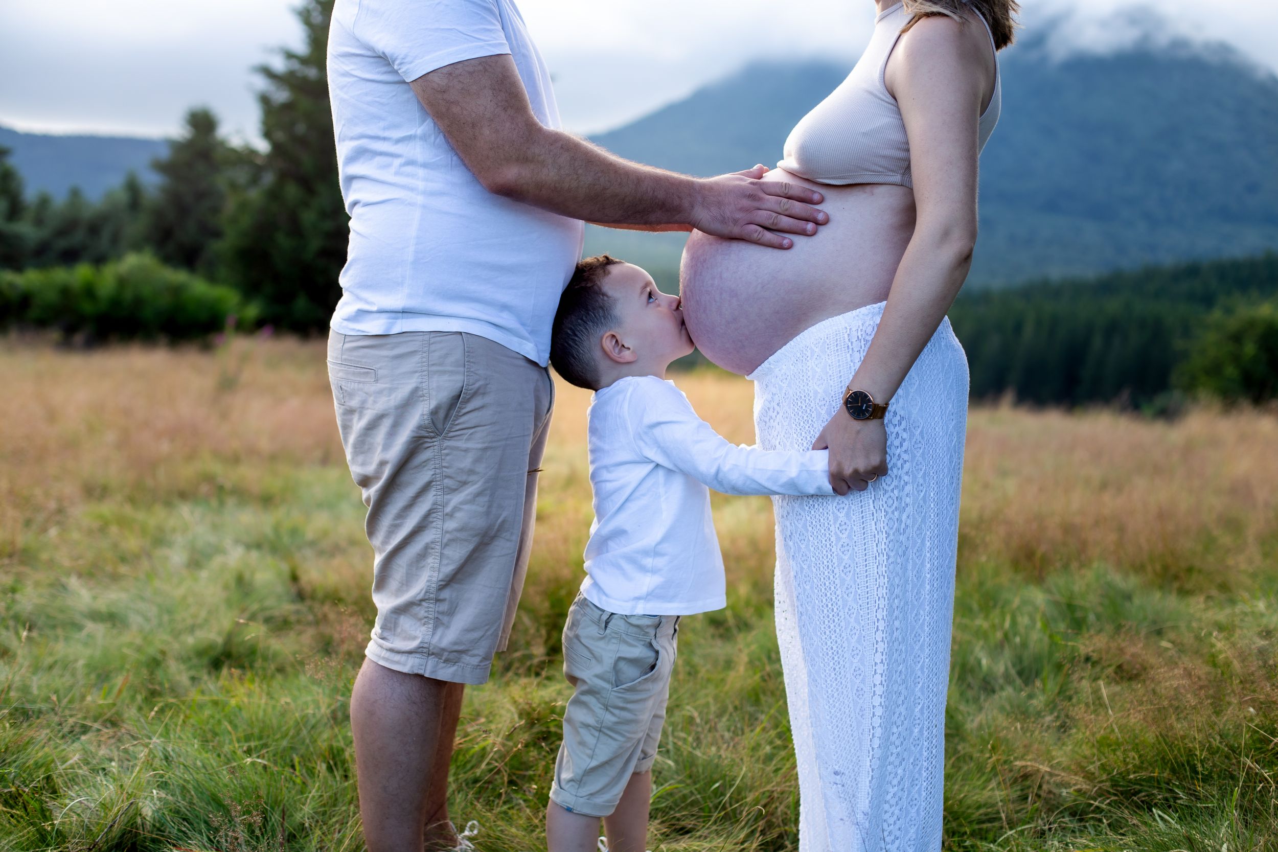 Photo de grossesse en extérieur à côté du puy de dôme – femme enceinte avec son mari et leur premier enfant