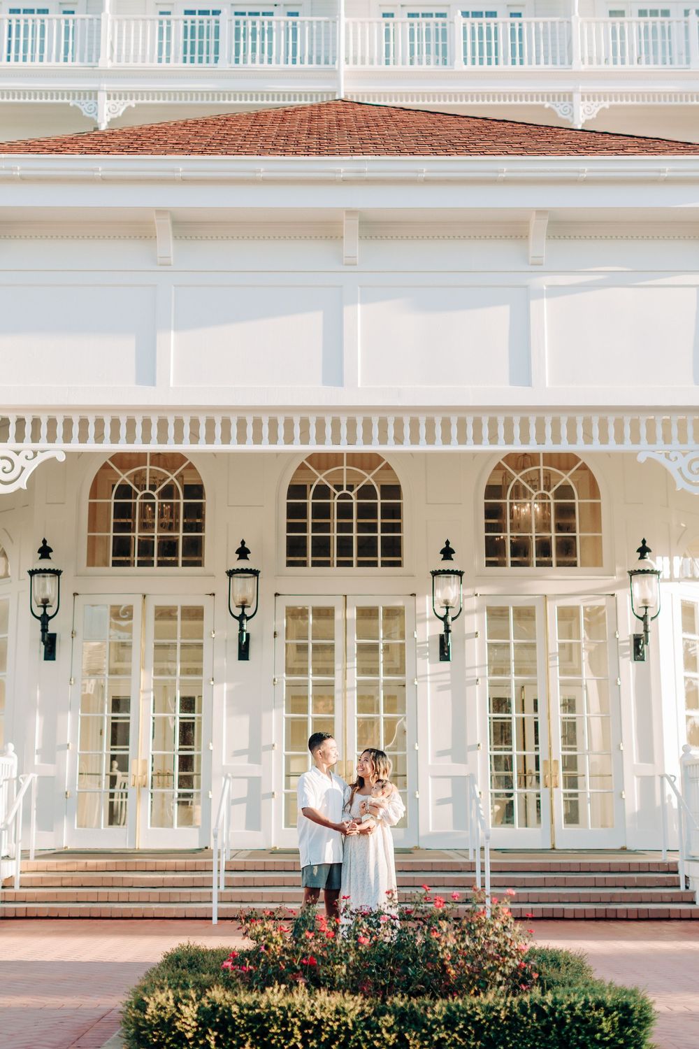 Elegant white colonial building exterior with arched windows, columns and steps as a beautiful location for family photo session in Orlando