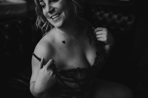 Black and white intimate boudoir portrait showing soft natural lighting and delicate lace details.