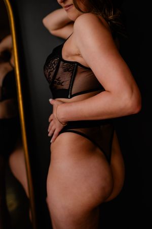 Side profile silhouettes of a pregnant figure in black lingerie against dark background showing progression of pregnancy.