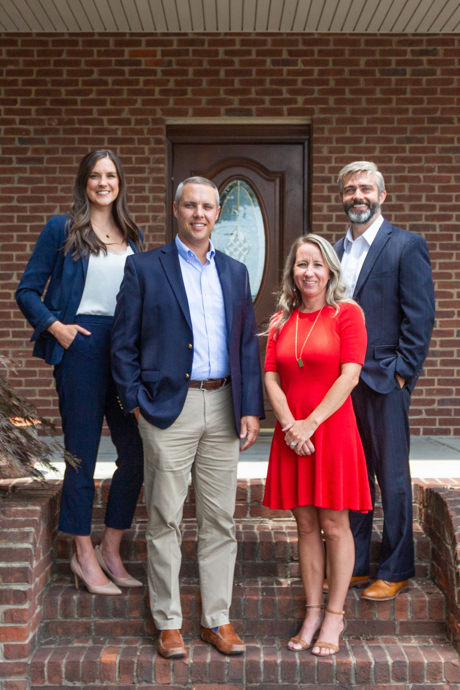 A team of four people smiling at the camera for a company photo.