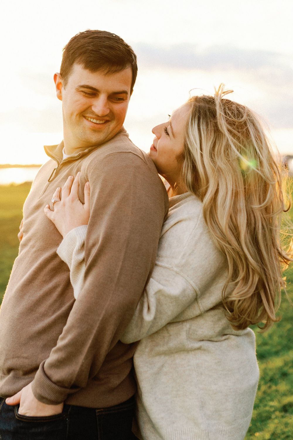 A couple embraces lovingly in a sun-drenched field during golden hour in a series of romantic candid moments.