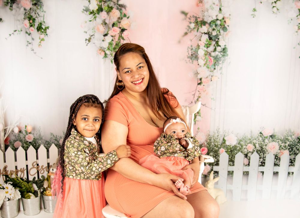 Sweet spring portrait setup with white picket fence and pink floral garden backdrop.