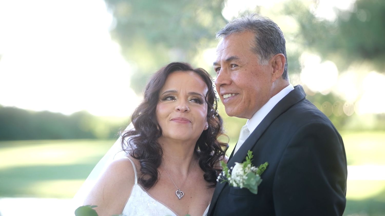 Close-up of newlyweds sharing intimate moment in garden setting.