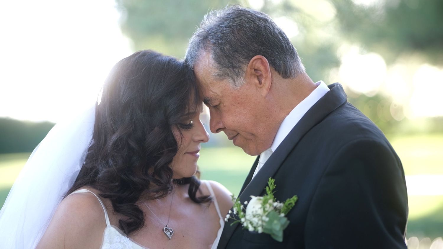 Intimate wedding portrait of couple in romantic outdoor setting.