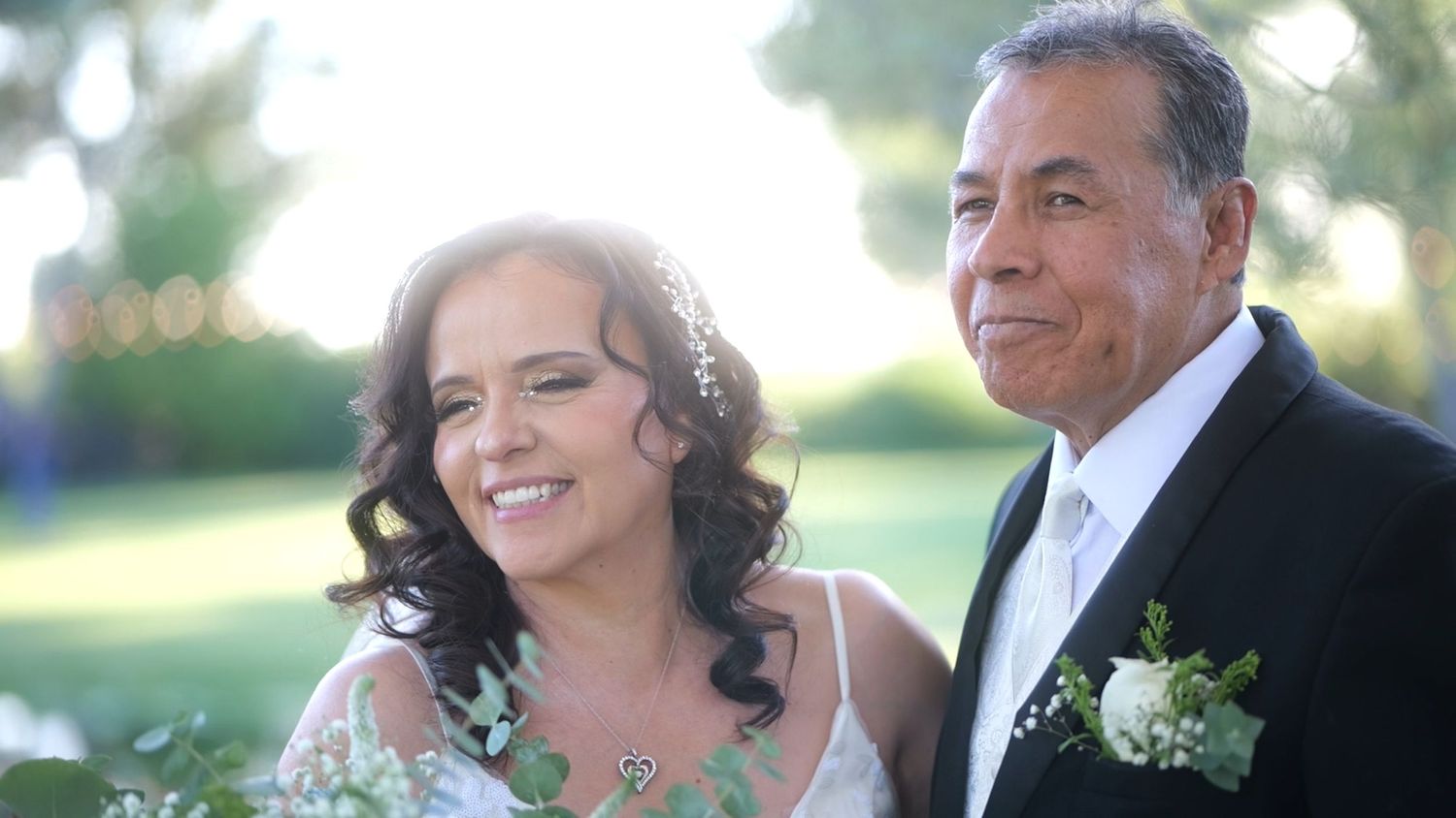 Joyful wedding portrait of couple smiling in garden setting.