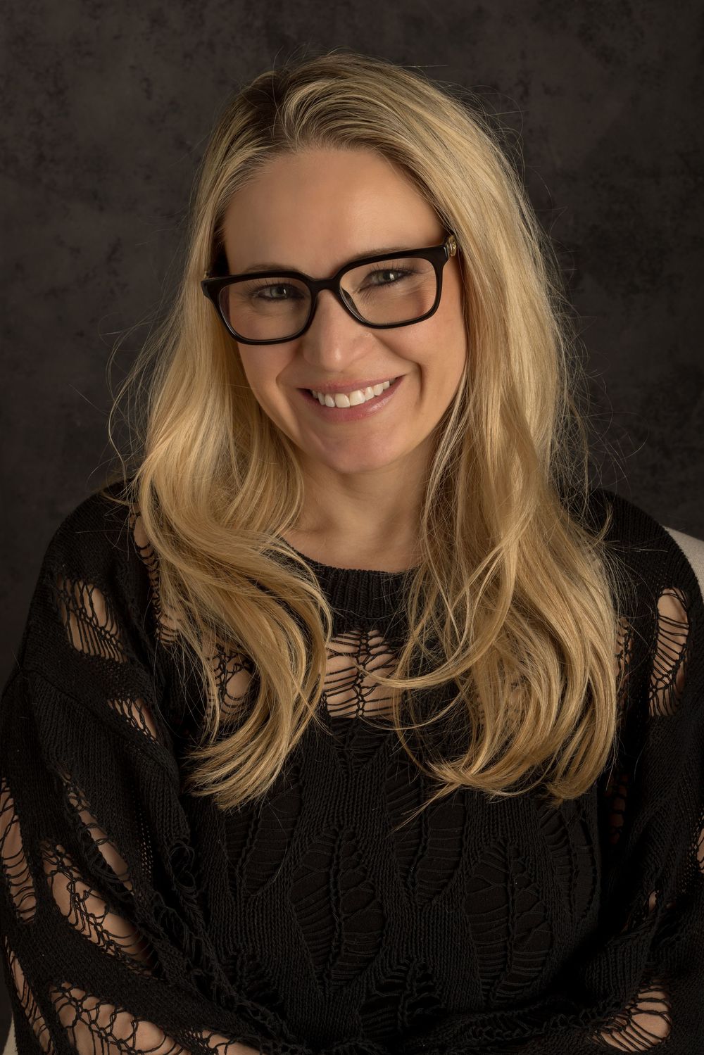 Professional portrait series showing a person with blonde hair wearing a black lace top against a dark background.