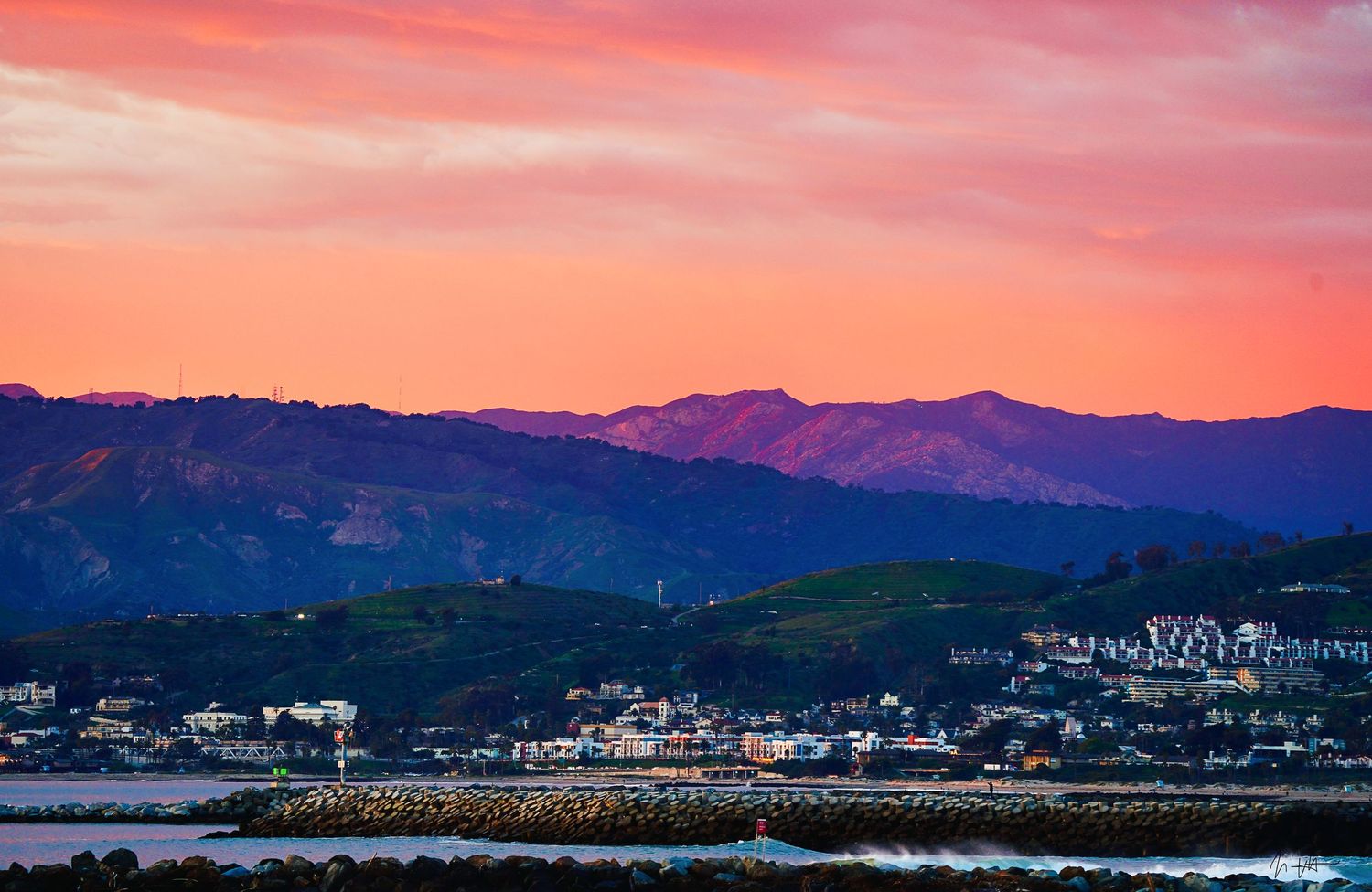 Sunset over Ventura with a sky glowing in soft amber and pink hues, casting gentle light and shadows across the landscape.The Image Plug