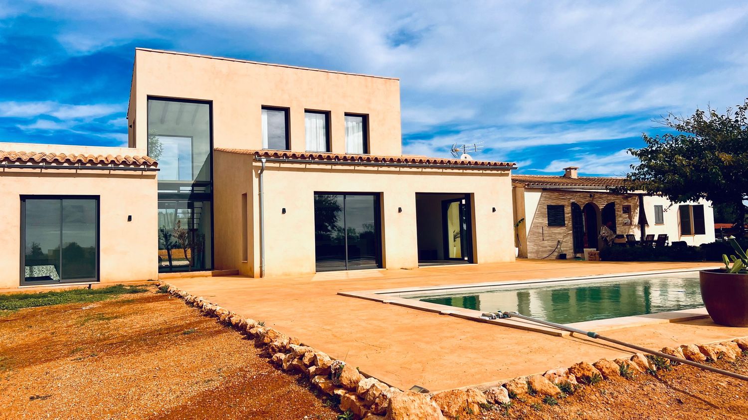 Modern Mediterranean villa with swimming pool and desert landscape design.