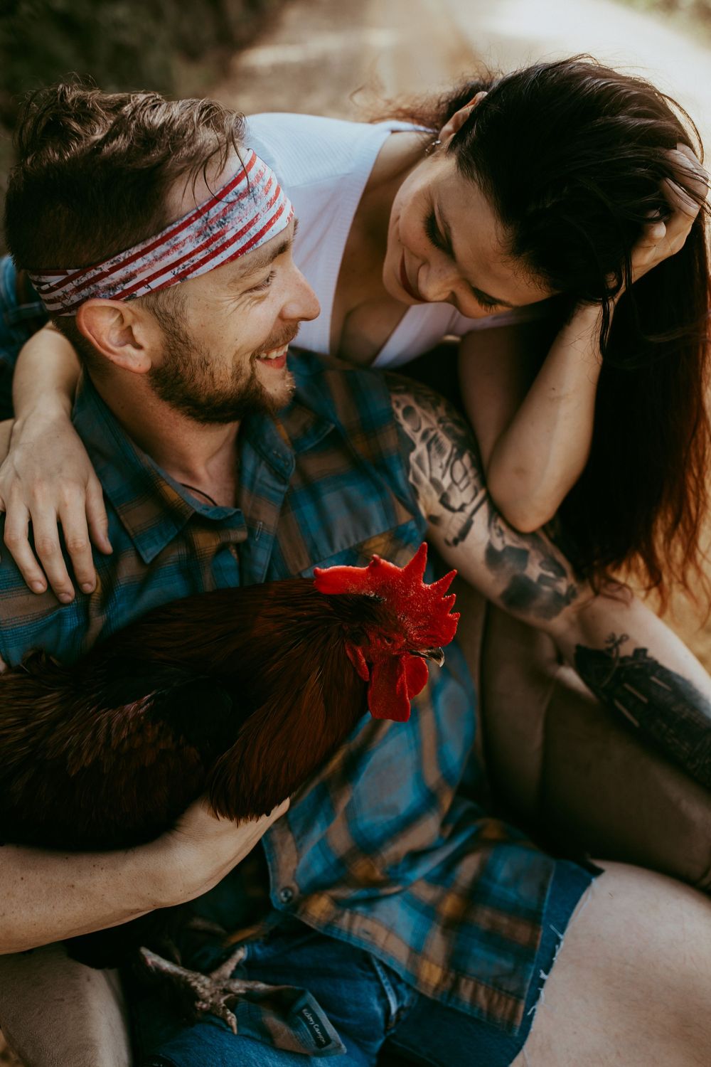 Romantic couple embracing while lying on bed with blue blanket and red flower.