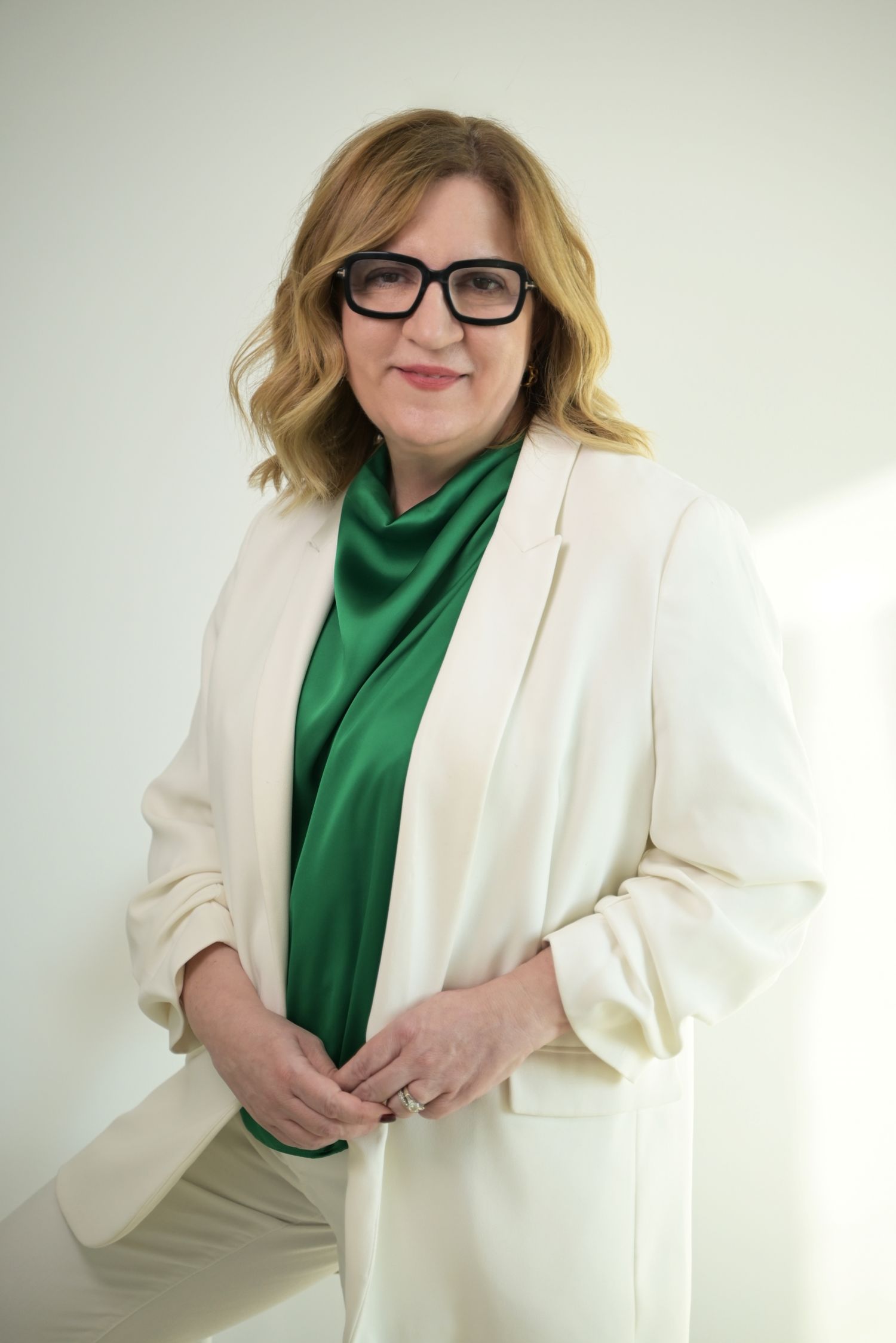 A professional woman wearing stylish glasses and white jacket